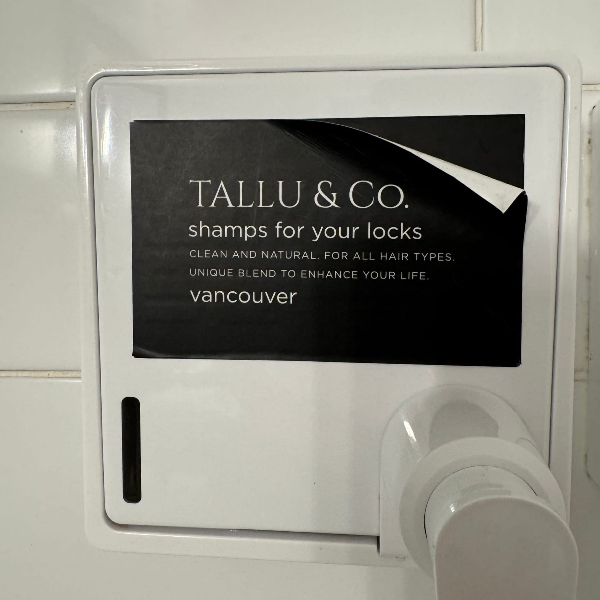 A picture of the shampoo dispenser in my hotel room shower, which is obnoxiously labeled "SHAMPS FOR YOUR LOCKS"